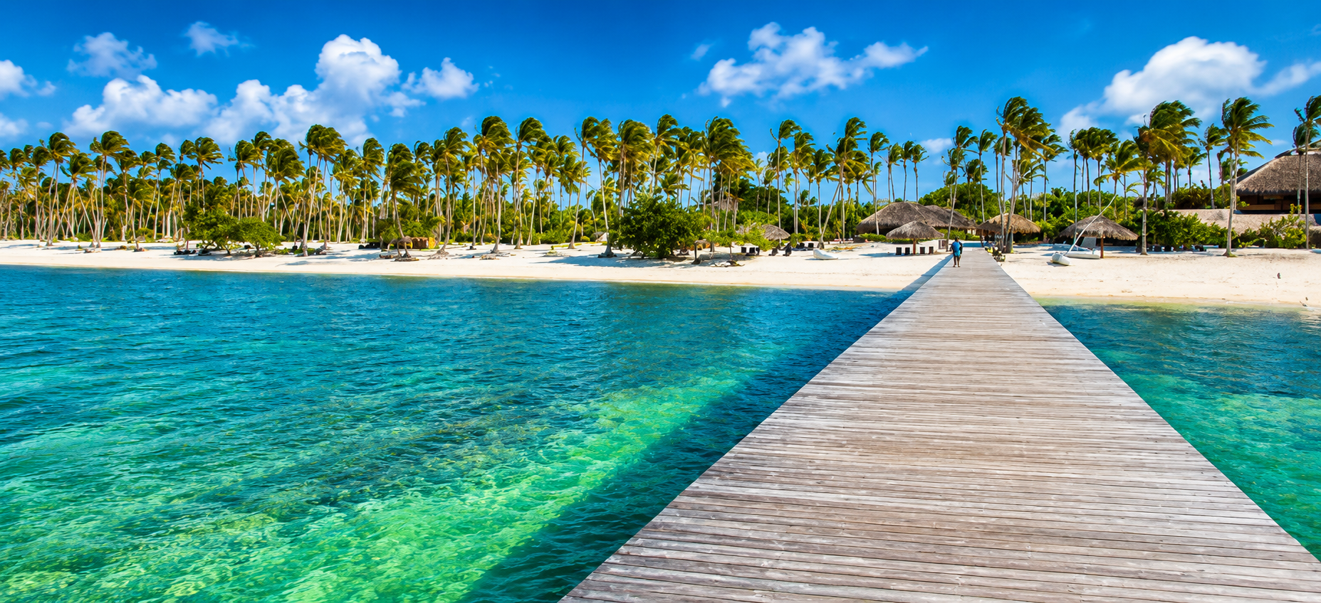 Wooden pier leading to a tropical beach and dolphin park in Punta Cana, Dominican Republic.
