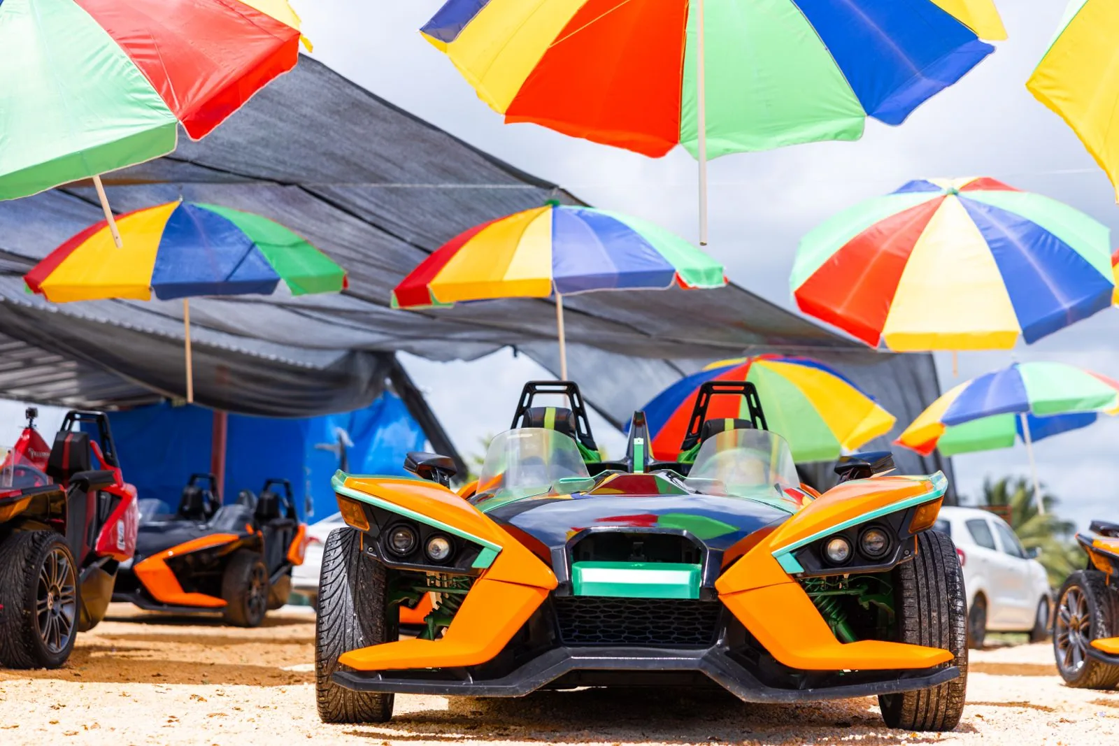 Polaris Slingshot displayed beneath colorful umbrellas at the Punta Cana Slingshot Hub