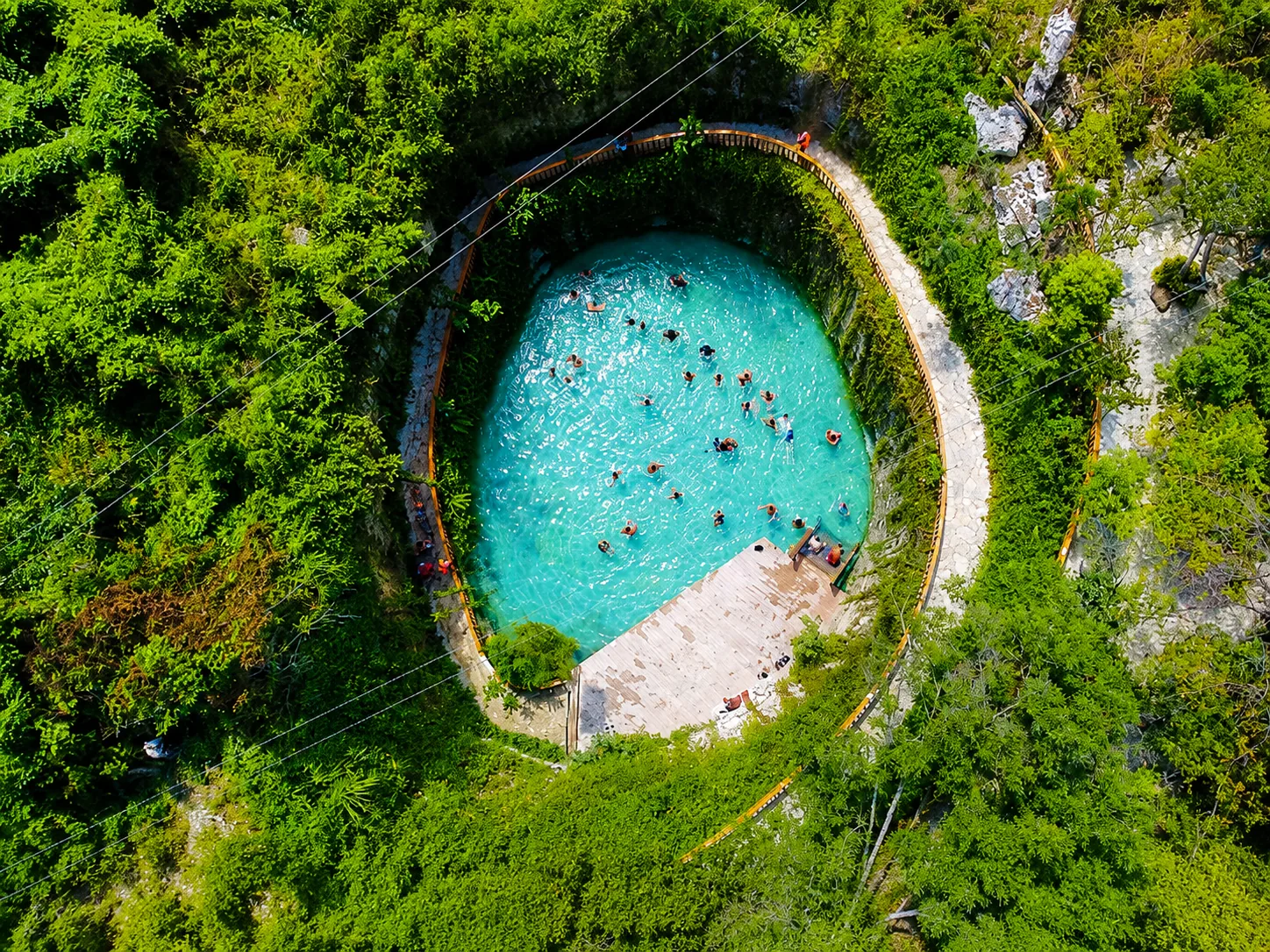 Aerial view of turquoise cenote at bavaro adventure Punta Cana surrounded by tropical jungle