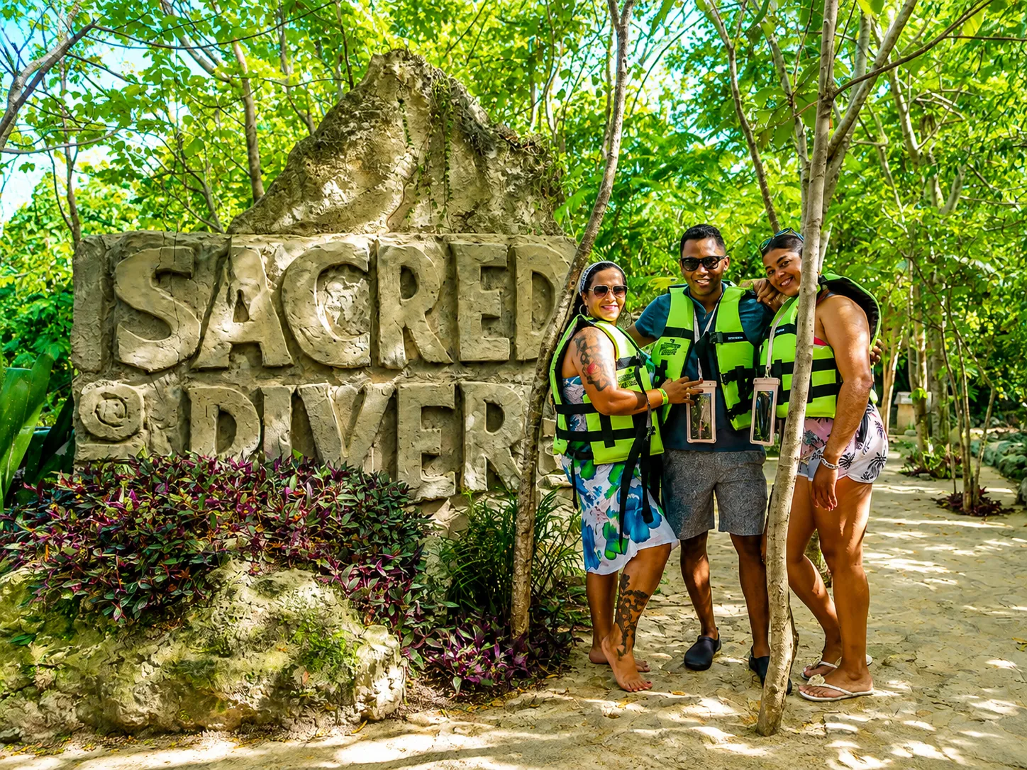Guests wearing life jackets beside Sacred Diver sign at Scape Park Punta Cana