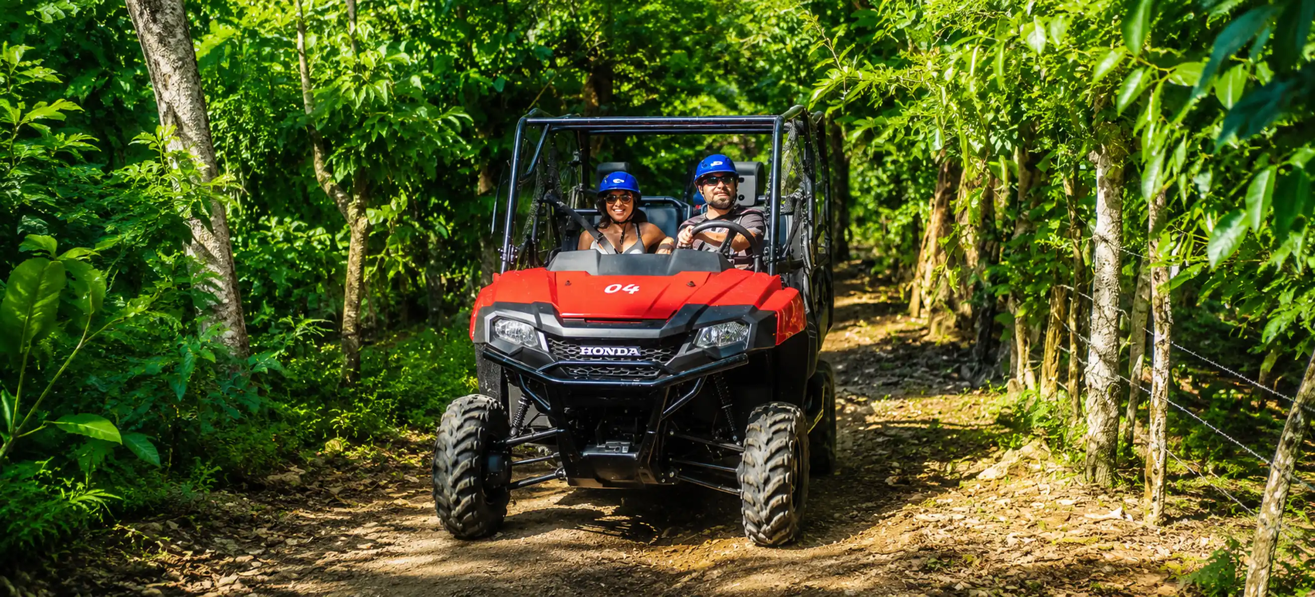Couple driving Honda buggy through jungle trail during Monkeyland excursion in Punta Cana
