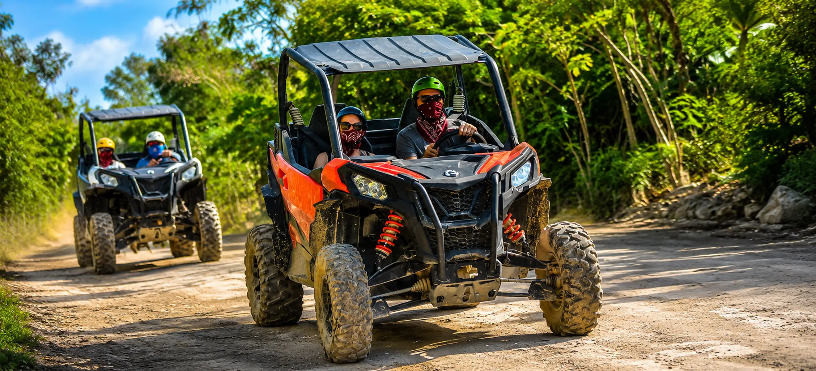 Guests driving UTV buggies through an off-road trail at Bávaro Adventure Park.