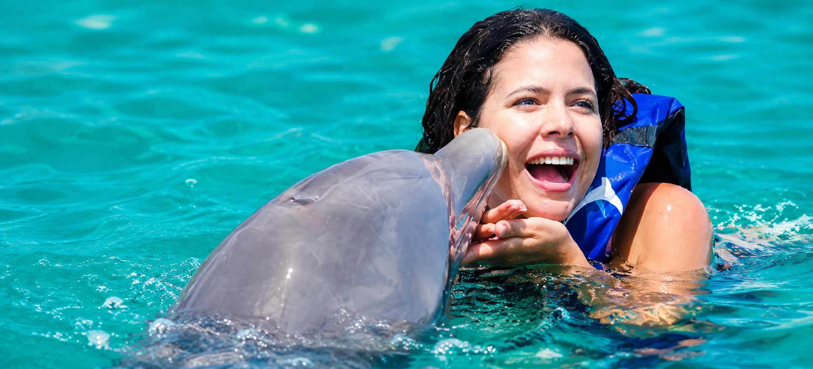 Guest receiving a dolphin kiss during a dolphin encounter in Punta Cana
