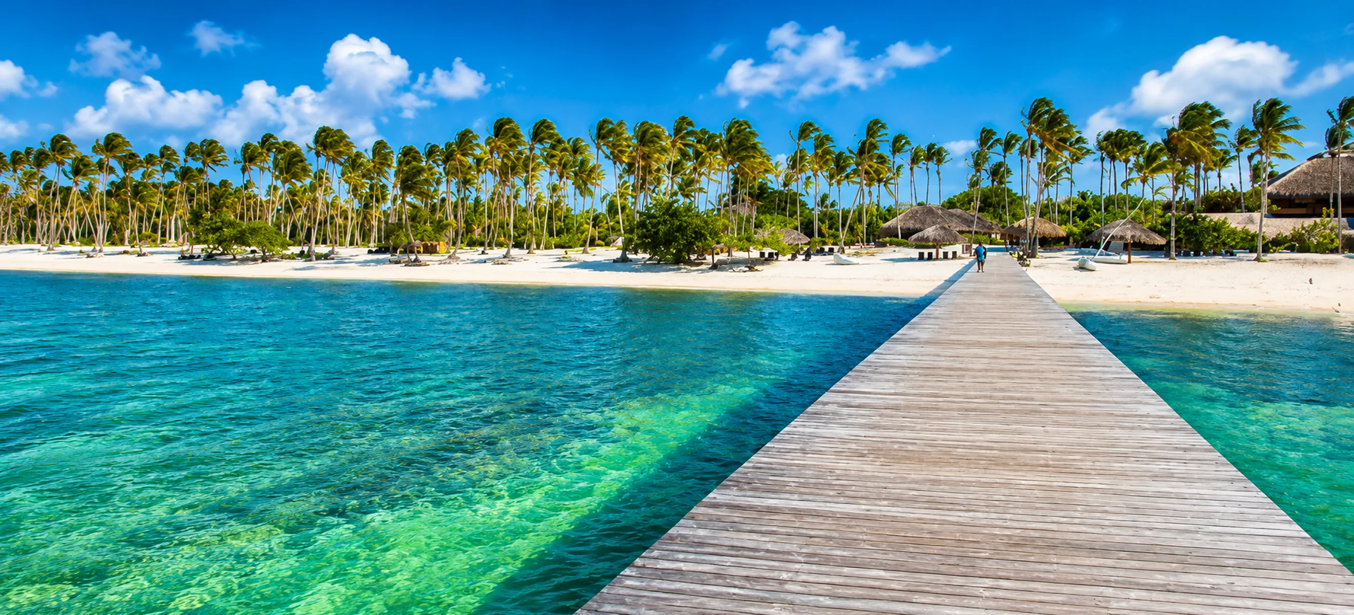 Wooden pier leading to tropical beach at Dolphin Explorer Punta Cana