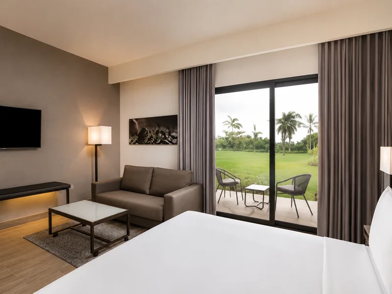 AC Hotel Punta Cana guest room with private terrace and tropical garden view