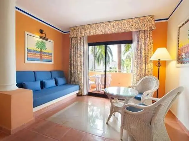 Bahia Principe Grand Punta Cana suite living area with tropical balcony view