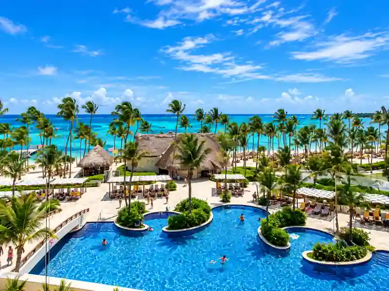 Punta Cana beachfront resort pool with palm trees and Caribbean ocean view