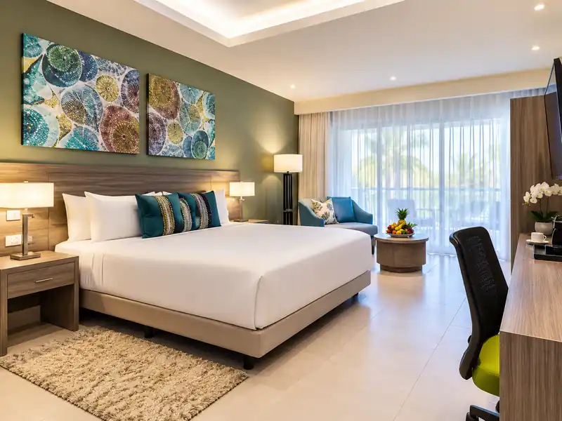 Modern Punta Cana resort room with king bed, tropical decor and balcony view