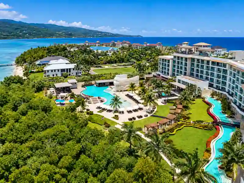 Aerial view of luxury beachfront resort with tropical pools, gardens and Caribbean ocean