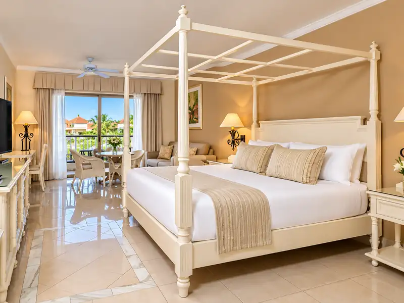 Bahia Principe Ambar luxury suite with four-poster king bed and tropical balcony in Punta Cana
