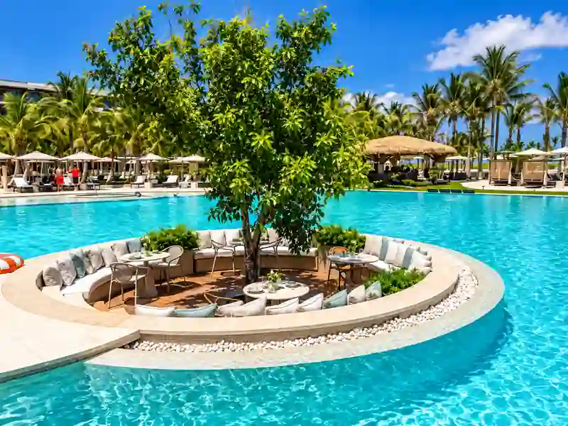Luxury Punta Cana resort swimming pool with tropical island lounge, palm trees and cabanas
