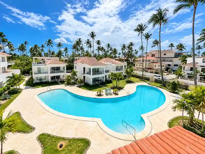 Tropical Punta Cana condo complex with swimming pool, villas and palm trees