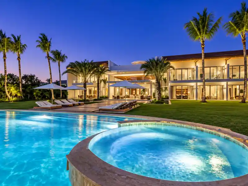 Casa de Campo luxury villa with illuminated swimming pool and tropical gardens at night