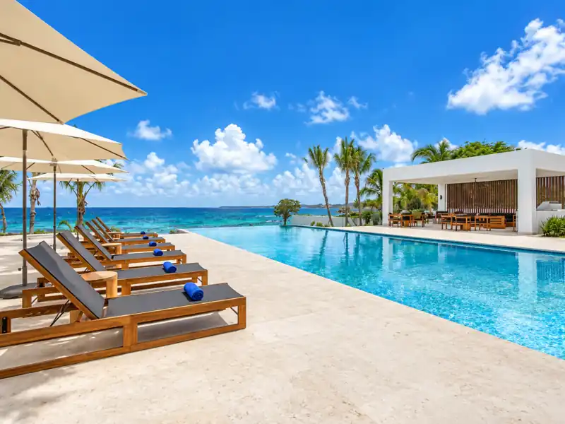 Casa de Campo oceanfront infinity pool with lounge chairs and Caribbean Sea views