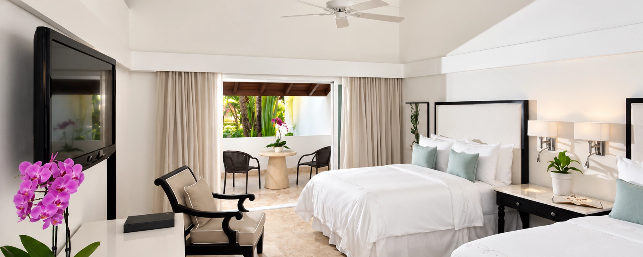 Bright deluxe guest room at Casa de Campo Resort with two beds and private tropical terrace