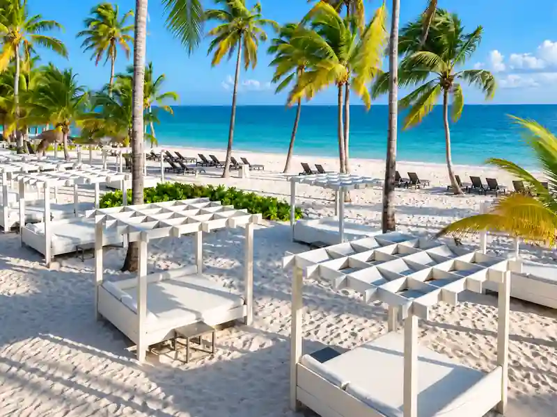 Catalonia Punta Cana beachfront cabanas with palm trees and turquoise Caribbean Sea.