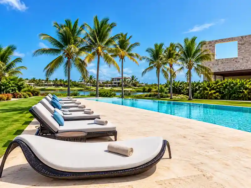 10 Cap Cana luxury private pool with tropical palm trees and poolside loungers.