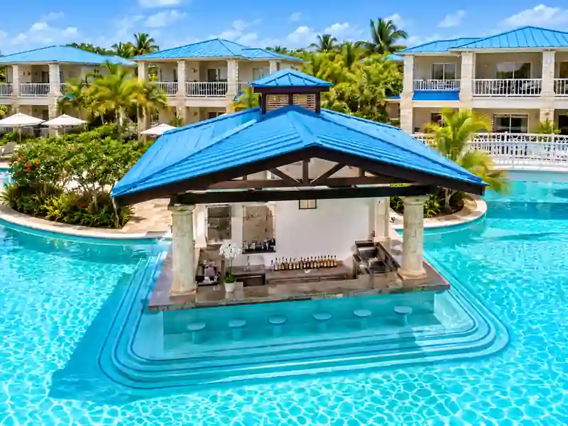 Dreams Cap Cana swim-up pool bar surrounded by tropical gardens and resort suites