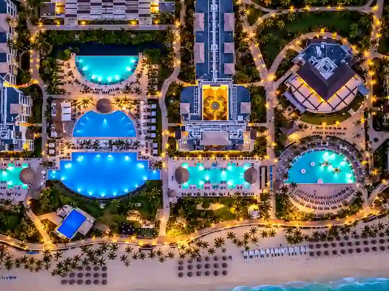 Aerial view of Hard Rock Hotel Punta Cana pools, tropical gardens and beachfront at twilight
